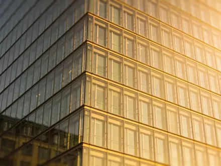 Ein modernes Bürogebäude mit Glasfassade bei Sonnenuntergang als Symbol für Immobilienentwicklung. - Foto: über boerse-global.de