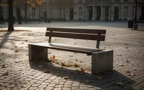 Eine leere Parkbank auf einem sonnigen, ruhigen Stadtplatz ohne Menschen. - Foto: über boerse-global.de