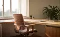 Ein heller, minimalistischer Arbeitsplatz mit einem ergonomischen Holzstuhl und einer Zimmerpflanze in natürlichem Tageslicht. - Foto: über boerse-global.de