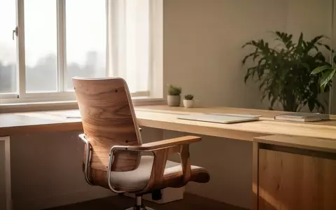 Ein heller, minimalistischer Arbeitsplatz mit einem ergonomischen Holzstuhl und einer Zimmerpflanze in natürlichem Tageslicht. - Foto: über boerse-global.de