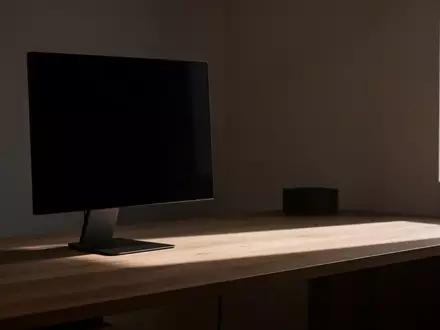 Ein minimalistischer, unbeleuchteter Arbeitsplatz mit einem dunklen, leeren Monitor in einem modern eingerichteten Raum. - Foto: über boerse-global.de