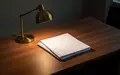 Ein leerer, aufgeräumter Schreibtisch mit einer Schreibtischlampe und einem Stapel unbeschriebener weißer Blätter. - Foto: über boerse-global.de