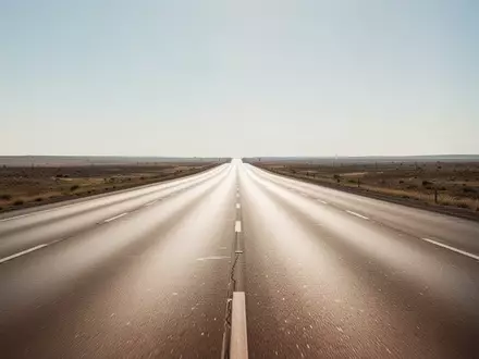 Eine leere, mehrspurige Autobahn bei klarem Wetter, die sich bis zum Horizont erstreckt. - Foto: über boerse-global.de