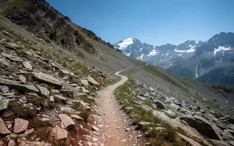 Ein gewundener Bergpfad führt einen steilen, felsigen Hang in einer alpinen Hochgebirgslandschaft hinauf. - Foto: über boerse-global.de