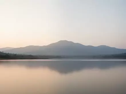 Eine weite, ruhige Berglandschaft bei Sonnenaufgang mit sanftem, diffusem Licht, die eine Atmosphäre der Stille vermittelt. - Foto: über boerse-global.de