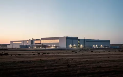 Ein modernes, fensterloses Industriegebäude in einer weiten texanischen Landschaft bei Dämmerung. - Foto: über boerse-global.de
