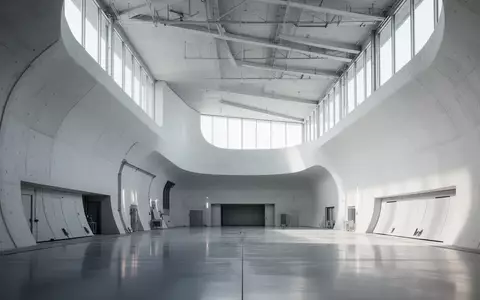Minimalistische, architektonische Windkanal-Testanlage mit geschwungenen Betonwänden und diffusem Tageslicht. - Foto: über boerse-global.de