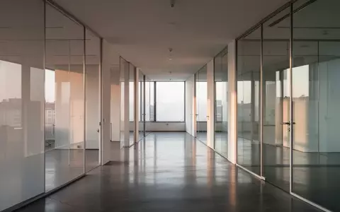 Ein minimalistisches, modernes Büro-Interieur mit klaren architektonischen Linien und sanftem Tageslicht. - Foto: über boerse-global.de