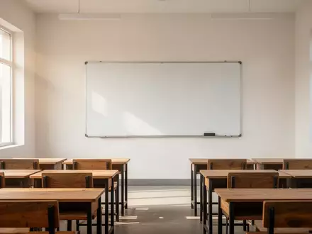 Ein heller, leerer Klassenraum in einer Schule in Punjab mit ordentlich aufgereihten Holztischen vor einer leeren Tafel. - Foto: über boerse-global.de