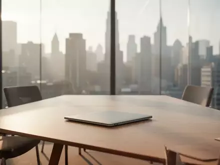 Ein minimalistisch eingerichteter, moderner Konferenzraum mit weichem Tageslicht und Blick auf eine verschwommene Stadt. - Foto: über boerse-global.de