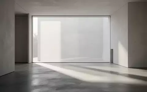 Modernes, minimalistisches Interieur mit klaren Linien und natürlichem Lichteinfall auf einem polierten Betonboden. - Foto: über boerse-global.de