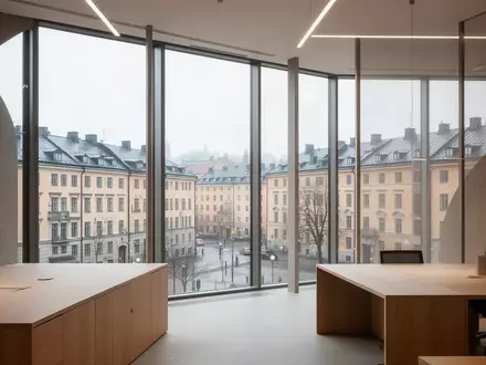 Ein minimalistisches, modernes Büro in Stockholm mit großen Fenstern und Blick auf eine ruhige Stadtlandschaft bei Tageslicht. - Foto: über boerse-global.de