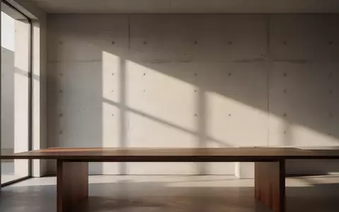 Ein minimalistischer, moderner Innenraum mit sanftem Tageslicht und klaren geometrischen Schatten auf einer Betonwand. - Foto: über boerse-global.de