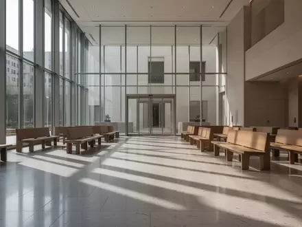 Ein minimalistischer, leerer Gerichtssaal mit großen Glasfenstern und Steinboden in einem modernen Gebäude. - Foto: über boerse-global.de