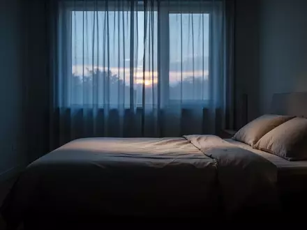 Ein ruhiges, in sanftes Morgenlicht getauchtes Schlafzimmer mit einem unbenutzten, ordentlich gemachten Bett. - Foto: über boerse-global.de
