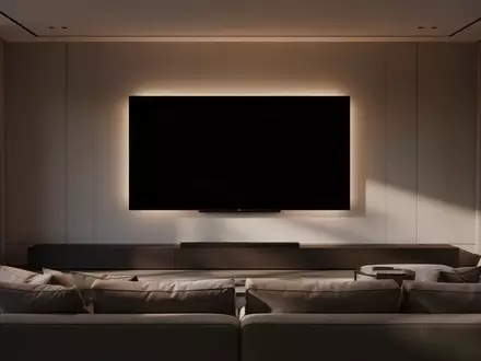 Ein minimalistisch eingerichtetes Wohnzimmer mit einem großen, ausgeschalteten Fernseher an der Wand. - Foto: über boerse-global.de