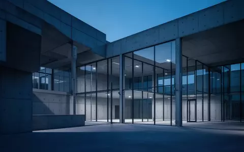 Minimalistische moderne Architektur aus Beton und Glas in der Abenddämmerung als Symbol für Sicherheit und Infrastruktur. - Foto: über boerse-global.de