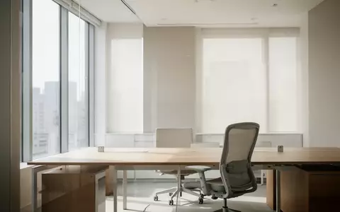 Ein minimalistisch gestalteter, heller Büroarbeitsplatz mit einem leeren Schreibtisch und einem ergonomischen Stuhl. - Foto: über boerse-global.de