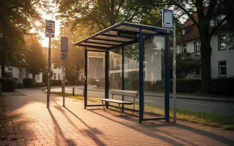 Eine leere, gepflegte Bushaltestelle in einem ruhigen Wohngebiet bei goldenem Sonnenlicht. - Foto: über boerse-global.de
