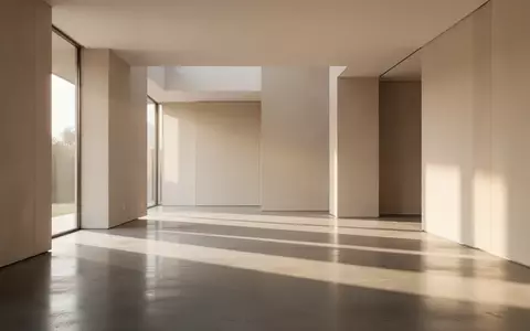 Ein minimalistischer, lichtdurchfluteter Raum mit klaren architektonischen Linien und sanften Schatten auf einem Betonboden. - Foto: über boerse-global.de