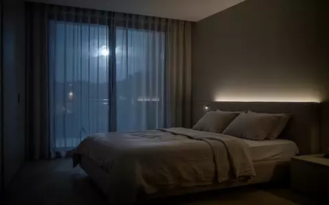 Ein minimalistisch eingerichtetes, ruhig wirkendes Schlafzimmer bei nächtlichem Mondlicht ohne medizinische Geräte. - Foto: über boerse-global.de