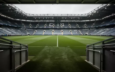 Leeres Fußballstadion bei Tageslicht mit Blick auf den grünen Rasen von der Spielertunnel-Perspektive. - Foto: über boerse-global.de