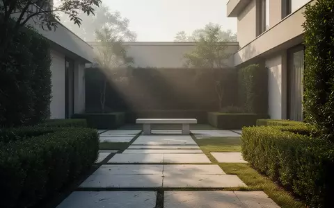 Ein minimalistisch gestalteter Garteninnenhof mit Steinwegen und Hecken in der Morgensonne. - Foto: über boerse-global.de
