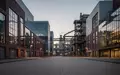 Ein weitläufiges Industriegelände eines Automobilwerks bei Dämmerung mit moderner Architektur und Backsteinfassaden. - Foto: über boerse-global.de