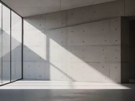 Minimalistische, sonnendurchflutete Architektur mit klaren Linien und geometrischen Schatten auf einer Betonwand. - Foto: über boerse-global.de
