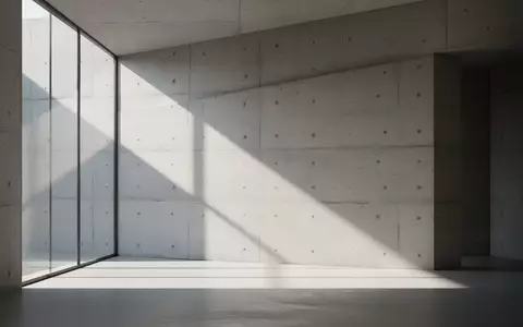 Minimalistische, sonnendurchflutete Architektur mit klaren Linien und geometrischen Schatten auf einer Betonwand. - Foto: über boerse-global.de