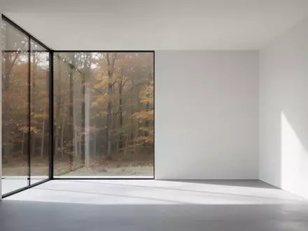 Minimalistischer, heller Innenraum mit klaren architektonischen Linien und Blick auf einen herbstlichen Wald - Foto: über boerse-global.de