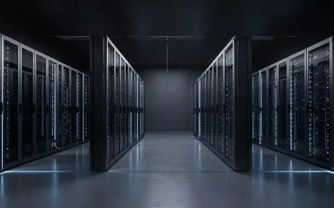 Ein minimalistischer, modern gestalteter Serverraum mit dunklen, metallischen Serverschränken in einer kühlen, bläulichen Beleuchtung. - Foto: über boerse-global.de
