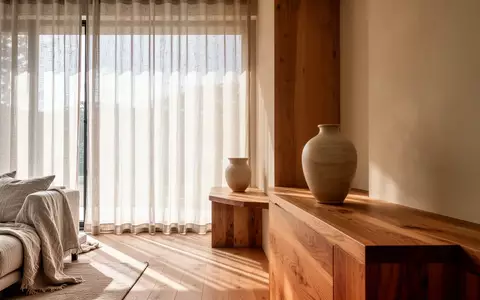 Ein minimalistisch gestalteter, lichtdurchfluteter Wohnraum mit Holzelementen, Leinenstoffen und sanftem Tageslicht. - Foto: über boerse-global.de