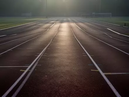 Eine leere, minimalistische Leichtathletikbahn im Licht der Morgendämmerung, die Ruhe und mentale Klarheit symbolisiert. - Foto: über boerse-global.de