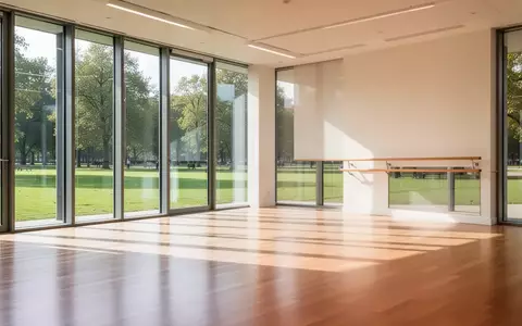 Ein heller, moderner Tanzsaal mit Parkettboden und einer Ballettstange an der Wand, durchflutet von natürlichem Tageslicht. - Foto: über boerse-global.de