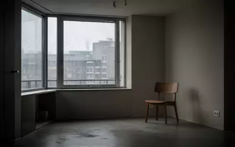 Ein minimalistisch eingerichteter, leerer Raum mit einem einzelnen Holzstuhl bei grauem Tageslicht. - Foto: über boerse-global.de