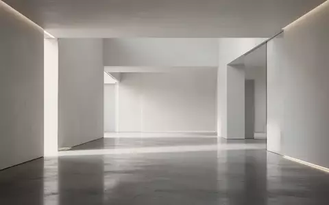 Minimalistisches, leeres Architekturinterieur mit geometrischen Linien und natürlichem Licht, das auf einem Betonboden reflektiert. - Foto: über boerse-global.de