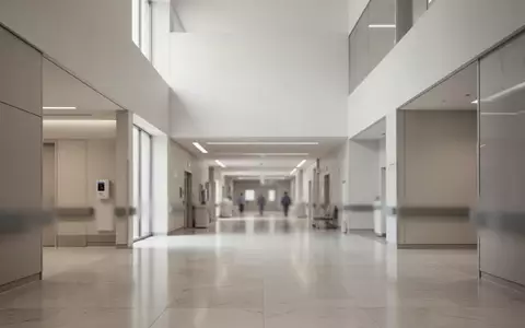Ein minimalistischer, leerer Flur in einem modernen öffentlichen Gebäude mit klaren architektonischen Linien und Tageslicht. - Foto: über boerse-global.de