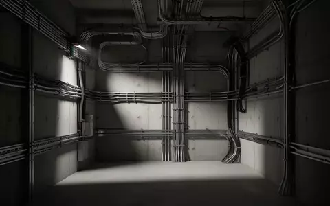 Dunkler, industrieller Technikraum mit massiven Kabelkanälen und Stahlleitungen an einer Betonwand. - Foto: über boerse-global.de