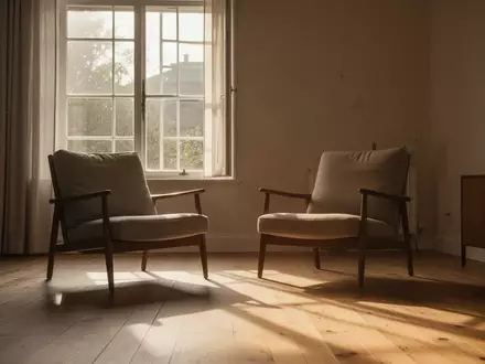 Ein leerer Sessel in einem sonnendurchfluteten Wohnzimmer, der die häusliche Atmosphäre und Stille symbolisiert. - Foto: über boerse-global.de