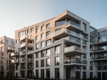 Ein modernes Berliner Wohngebäude mit klarer Architektur unter einem klaren Himmel. - Foto: über boerse-global.de