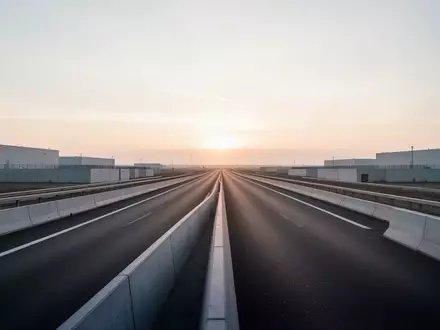 Eine leere, moderne Autobahn in einer minimalistischen europäischen Industrielandschaft bei Tagesanbruch. - Foto: über boerse-global.de