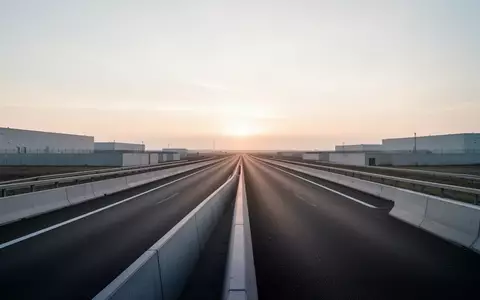 Eine leere, moderne Autobahn in einer minimalistischen europäischen Industrielandschaft bei Tagesanbruch. - Foto: über boerse-global.de