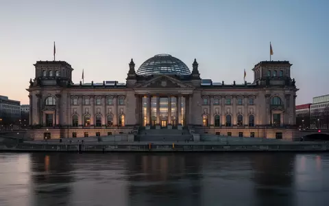 Das ReichstagsgebĂ€ude in Berlin in der DĂ€mmerung, aufgenommen aus der Ferne ĂŒber die Spree. - Foto: ĂŒber boerse-global.de