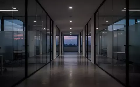 Ein minimalistischer, leerer Büroflur bei Dämmerung mit gedämpftem Licht und architektonischen Linien. - Foto: über boerse-global.de