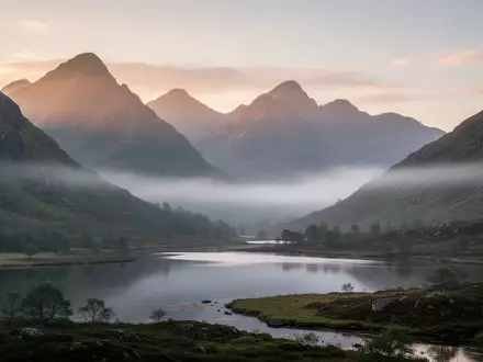 Eine neblige Berglandschaft in den britischen Highlands bei Sonnenaufgang, die Ruhe und Erholung symbolisiert. - Foto: ĂĽber boerse-global.de