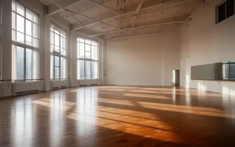 Ein heller, leerer Tanzsaal mit poliertem Holzboden und hohen Fenstern, durch die natürliches Tageslicht einfällt. - Foto: über boerse-global.de