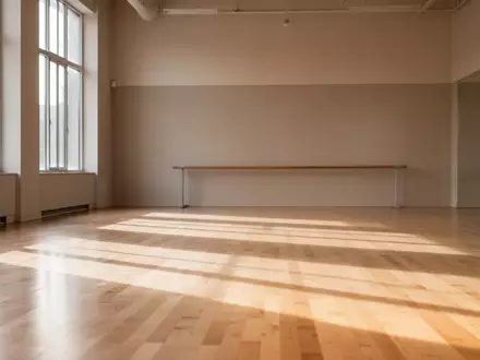 Ein heller, minimalistischer Tanzsaal mit Holzboden und einer Ballettstange an einer schlichten Wand. - Foto: über boerse-global.de