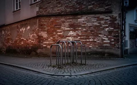 Ein verwaister Fahrradständer an einer Backsteinmauer in einer bayerischen Stadt in der Abenddämmerung. - Foto: über boerse-global.de