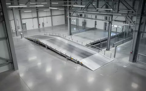 Leere, sterile Prüfhalle für Nutzfahrzeuge mit glattem Betonboden und industrieller Stahlarchitektur. - Foto: über boerse-global.de